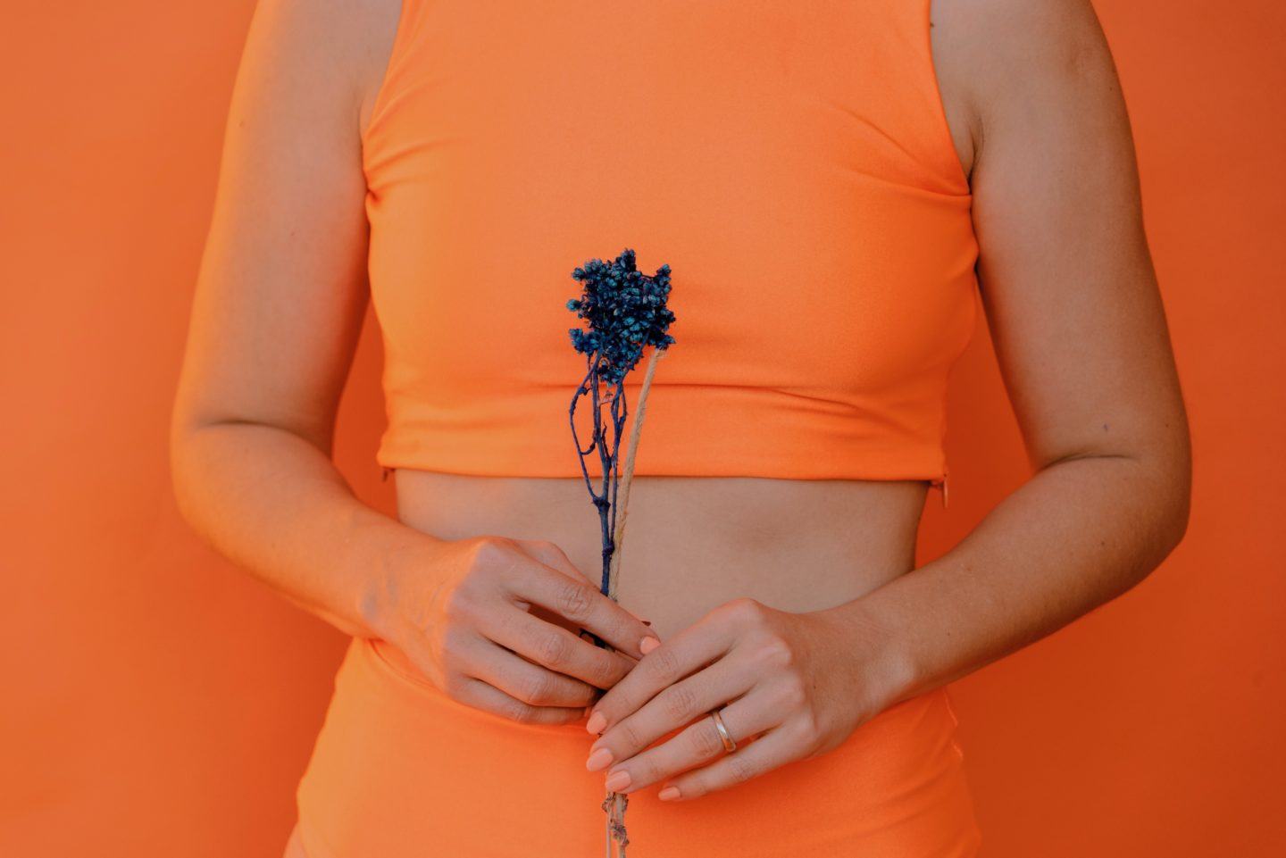 woman holding flowers near stomach