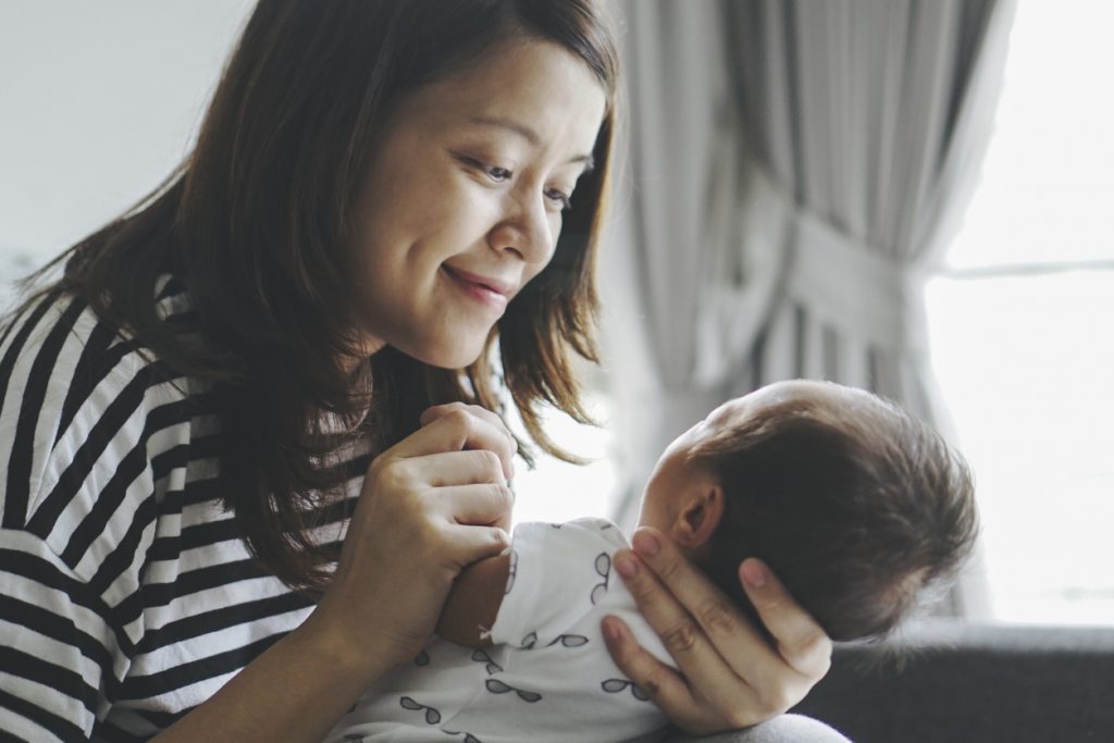 a picture of a new parent, practicing lactation, holding her newborn