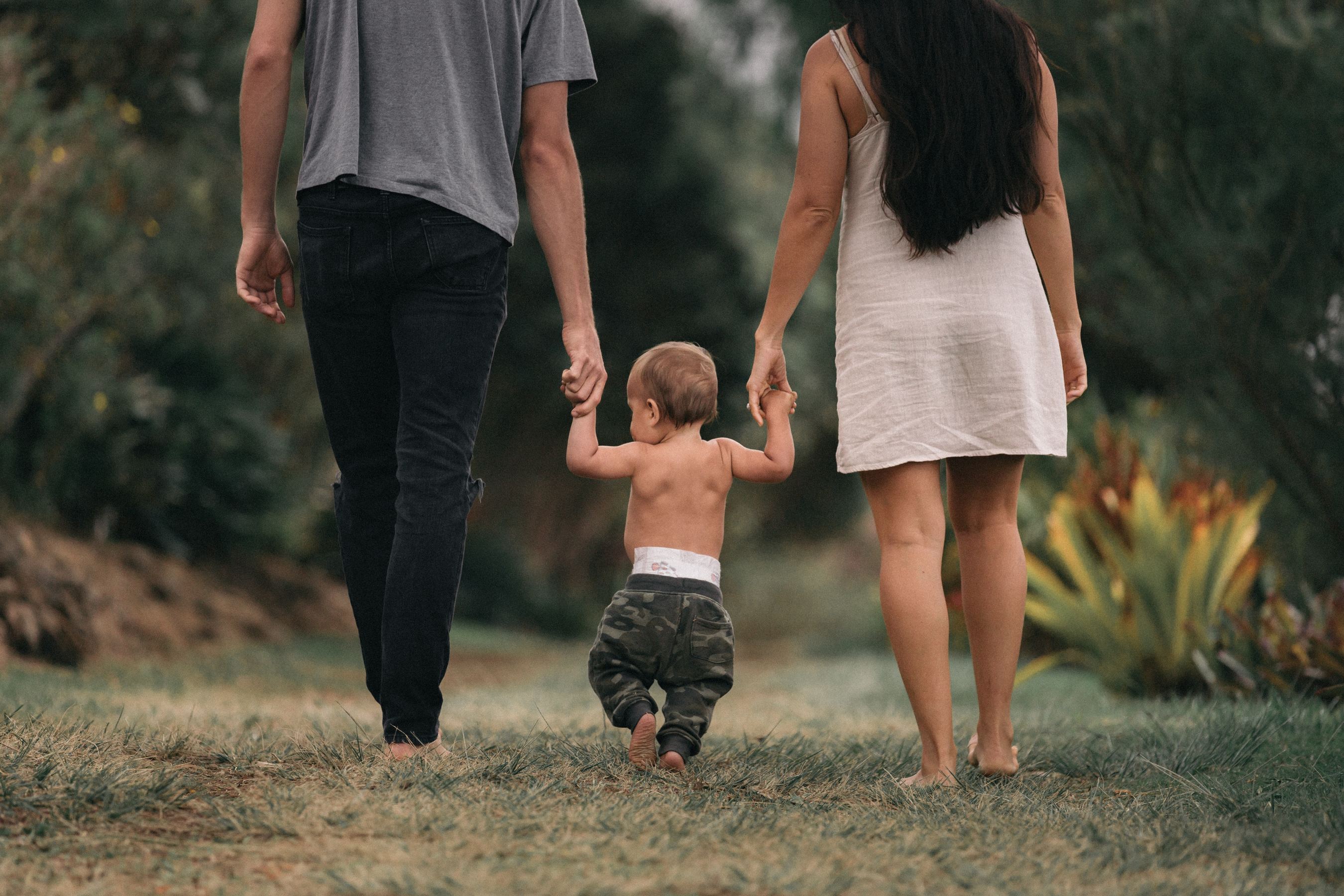 couple holding hands with their toddler