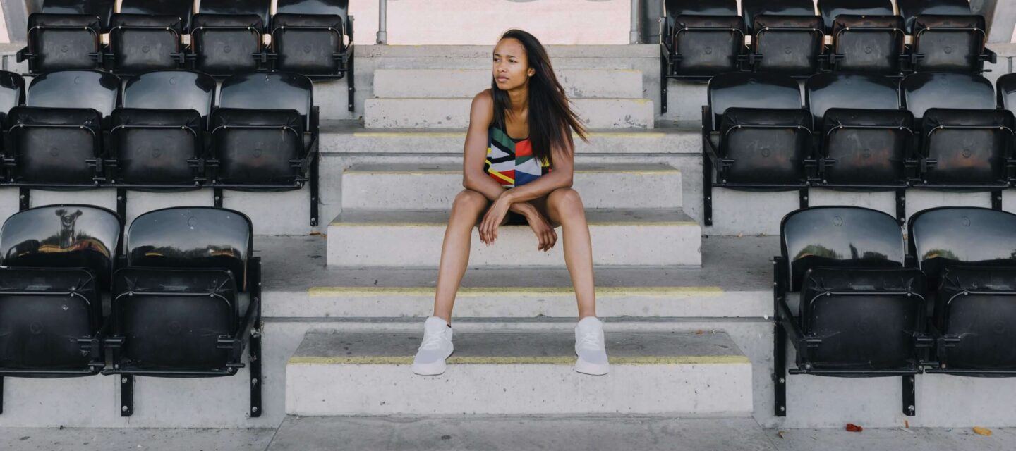 woman sitting on stairs, resting in between exercises
