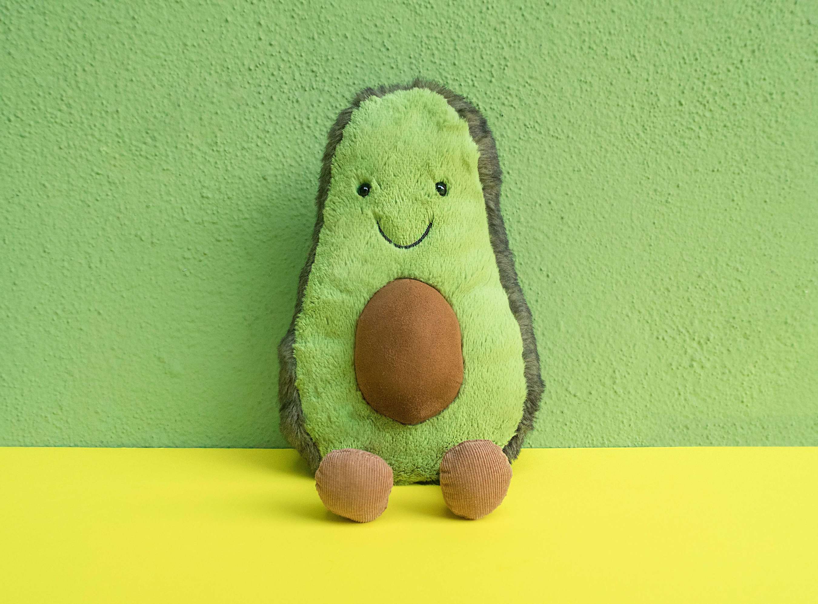 A toy avocado, split in half, exposing it's pit - symbolizing the abdomen