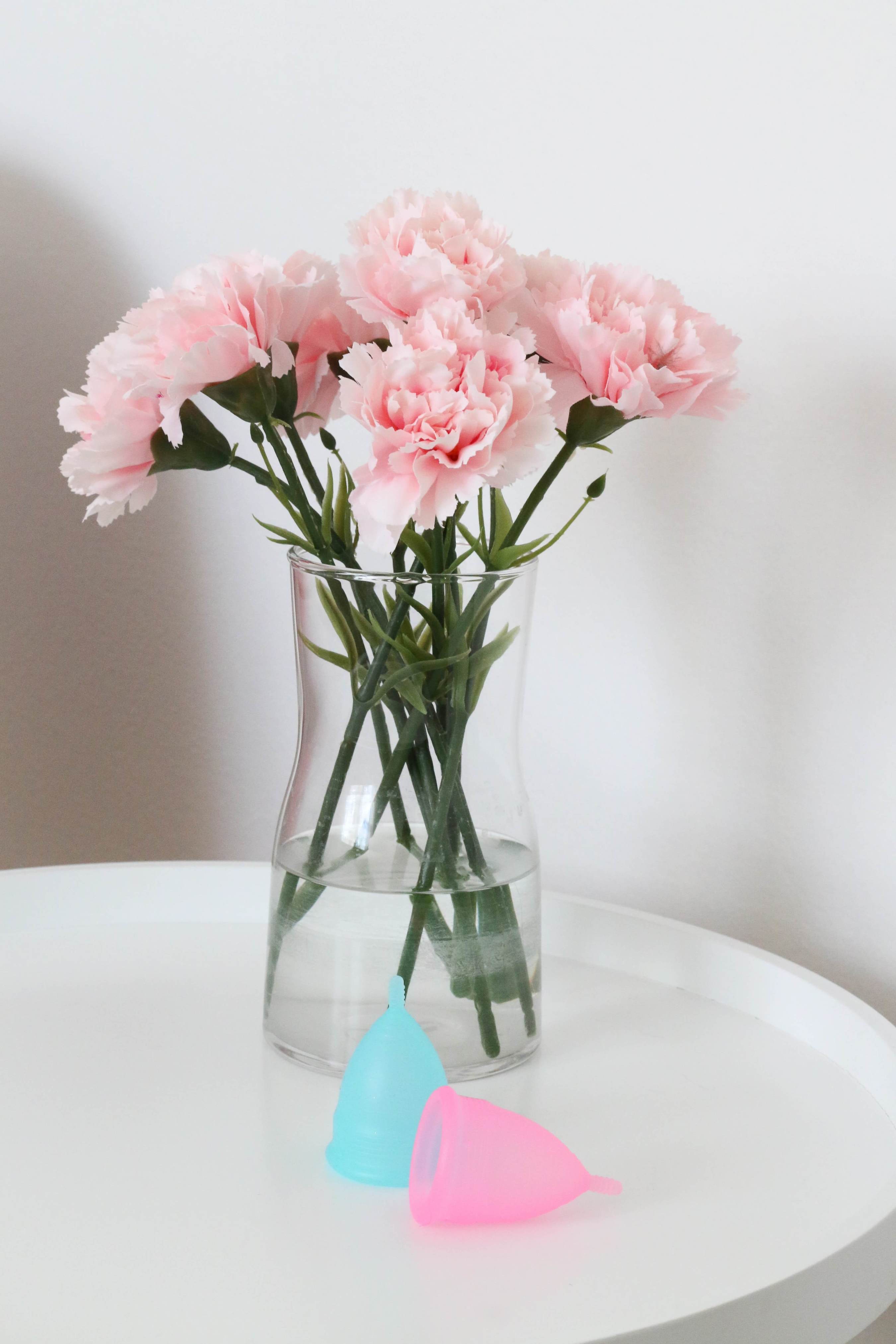 menstrual cups, on a table, against a floral background