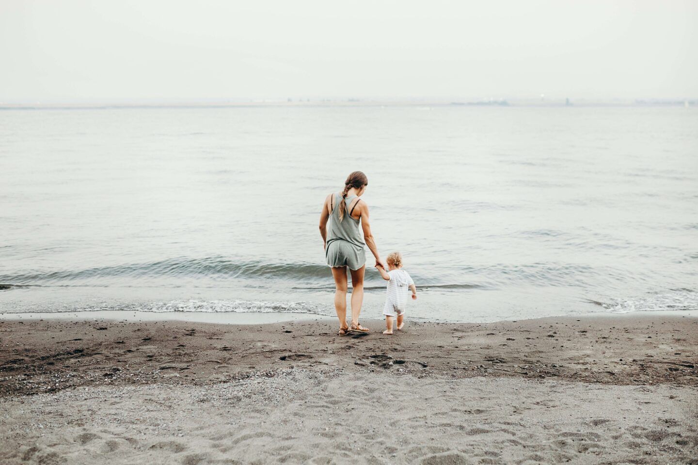 mom and new born baby enjoy the sand and beach
