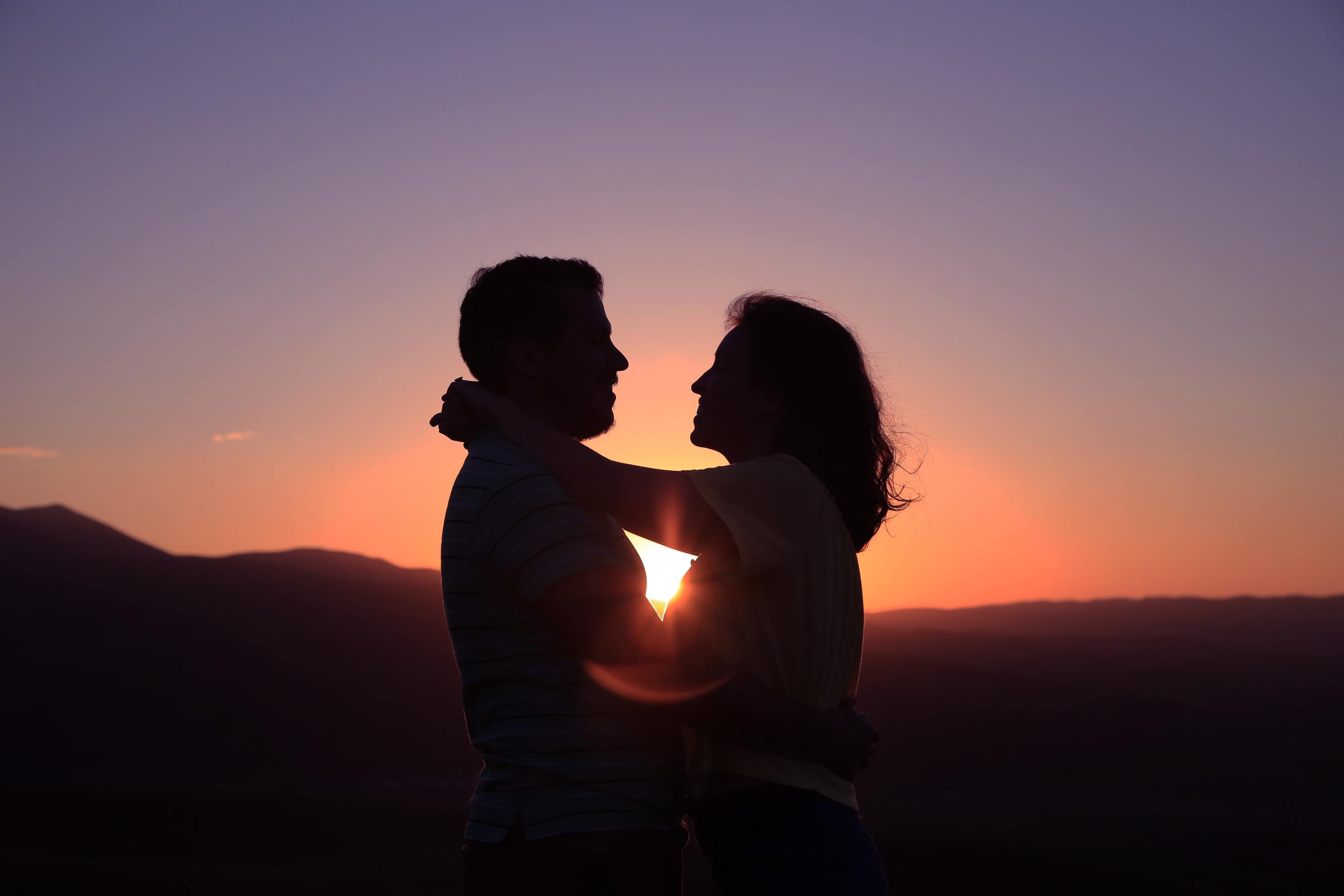 A couple embracing against a sunset