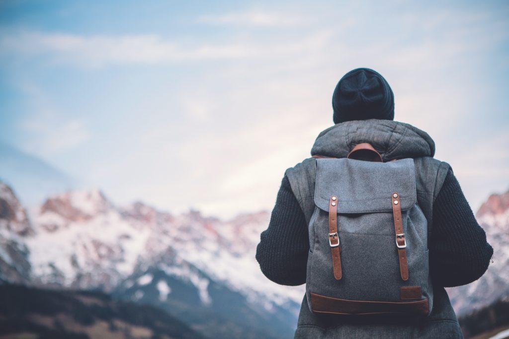 a person backpacking, looking out on the mountain range