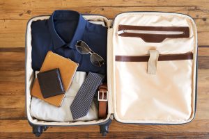 an open packed suitcase with a man's suit