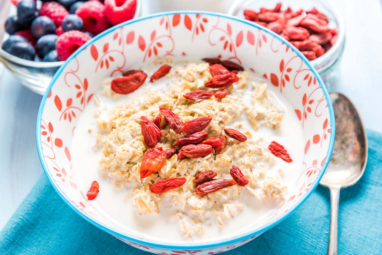 a bowl of oats and milk with gogi berries on top