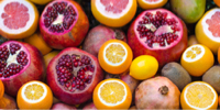 photo of cut open pomegranates, oranges, and lemons