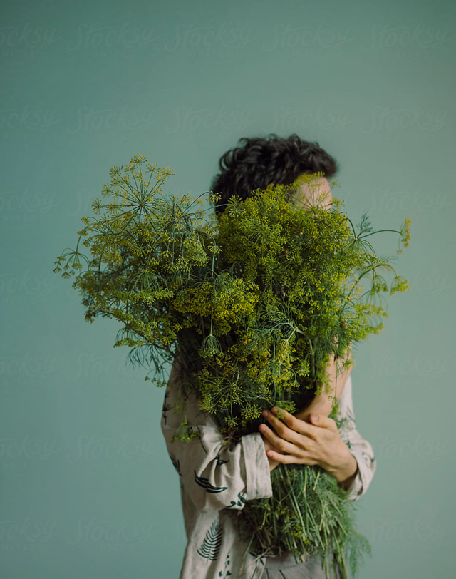 Man carrying a handful of fresh herbs