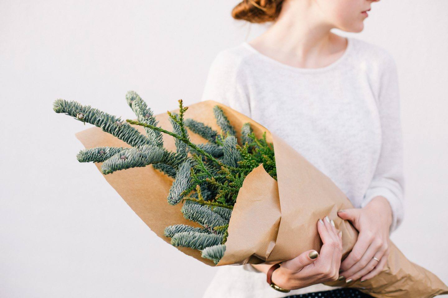 Woman holding a decorative bundle of wintery plants