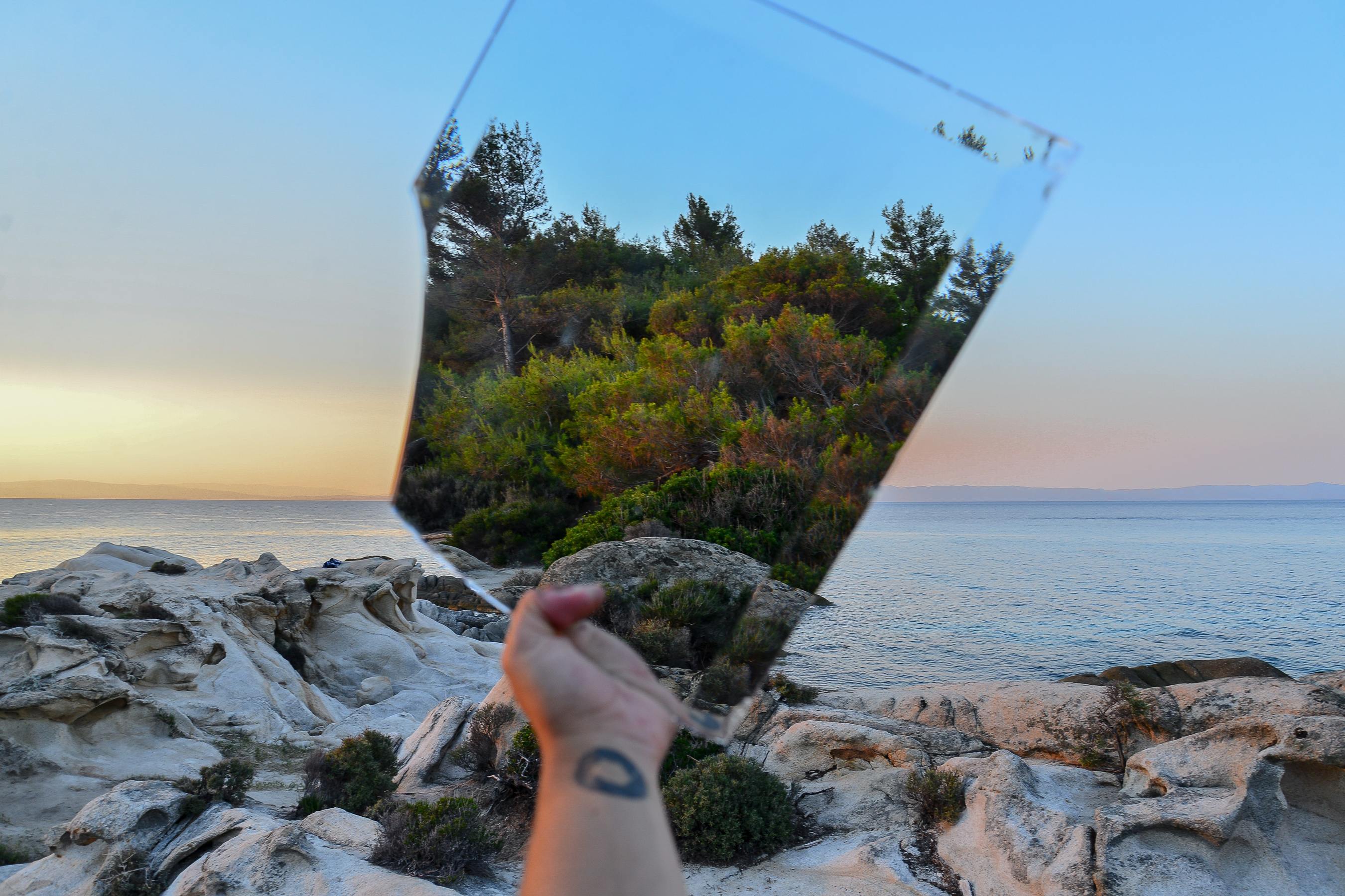 Person holding a mirror to reflect the environment behind them