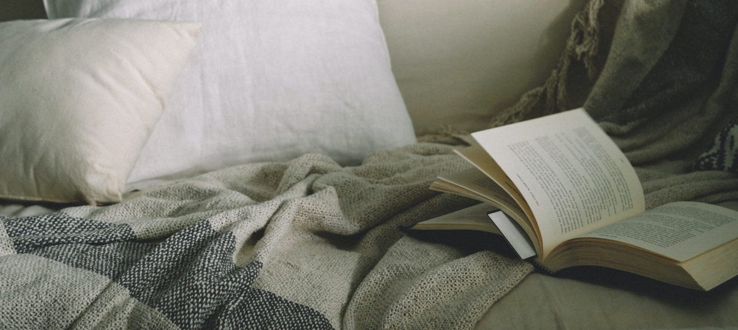 book on a couch with a blanket