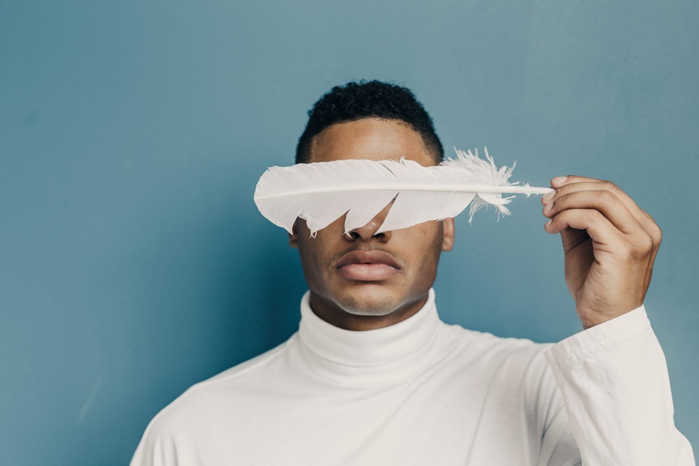 Man with feather over his eyes