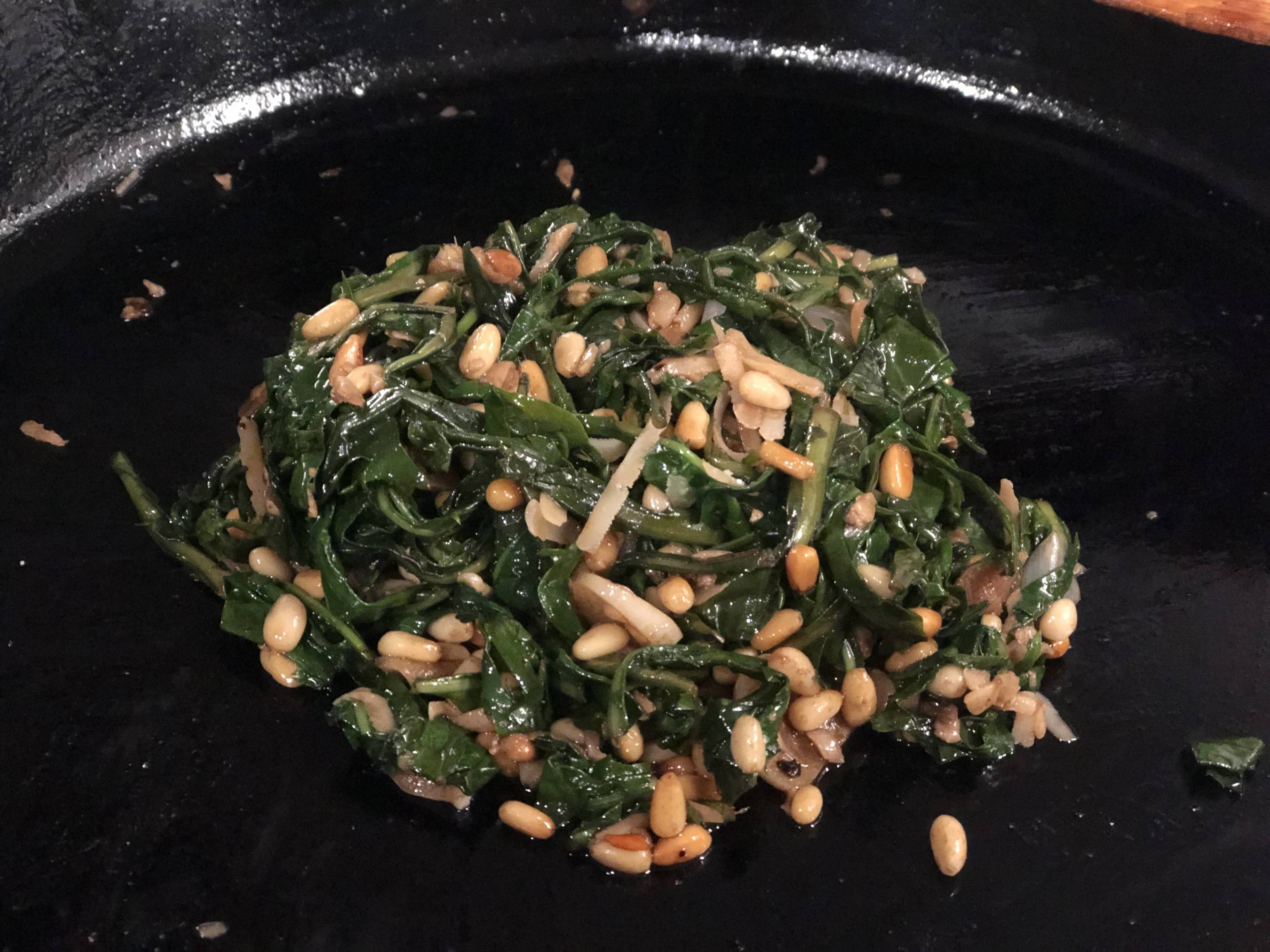 cooked dandelion greens with arugula, pine nuts, and parmesan cheese