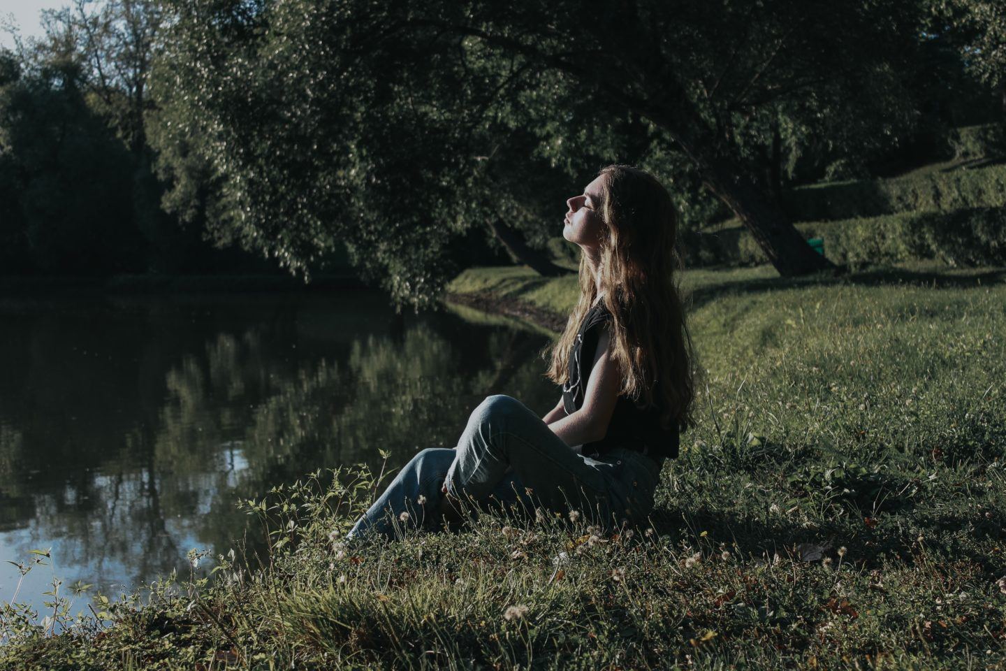 woman sitting near creek