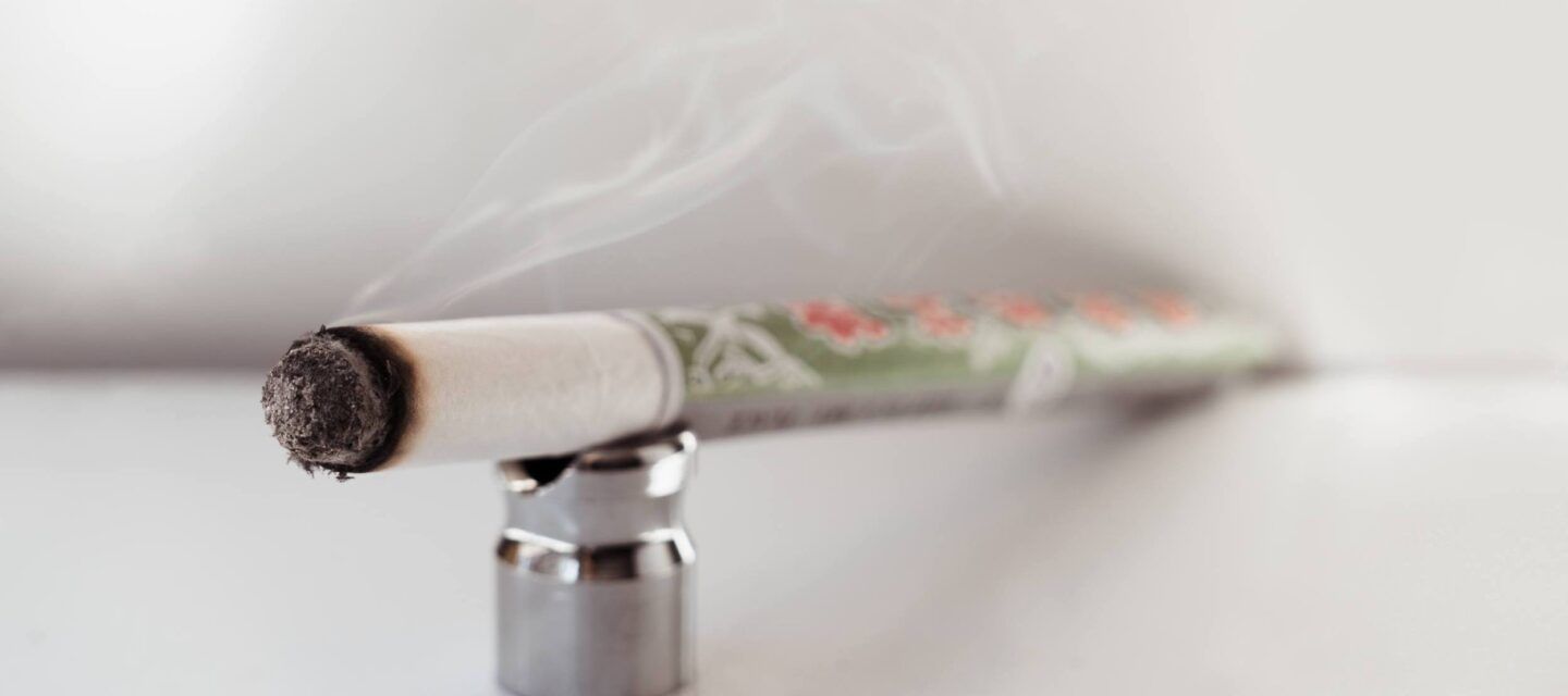 A stick of moxa, a traditional chinese dried herb, ignited with a soft smoke wafting over it