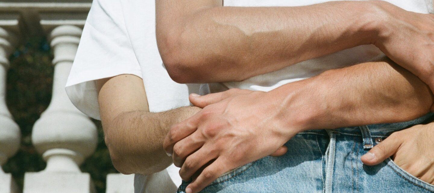 a closeup of two white men holding each other