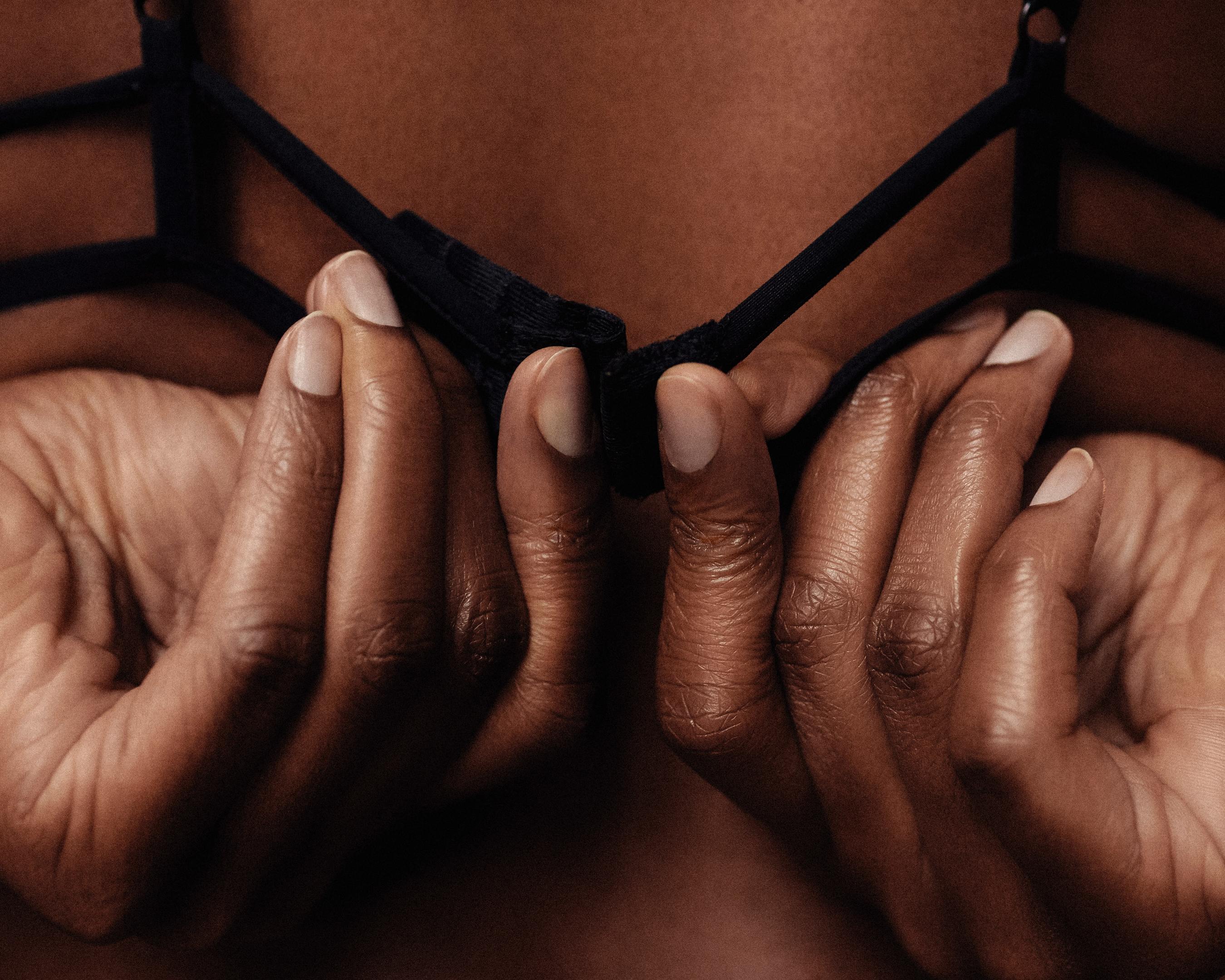 black woman undoing the back of her bra
