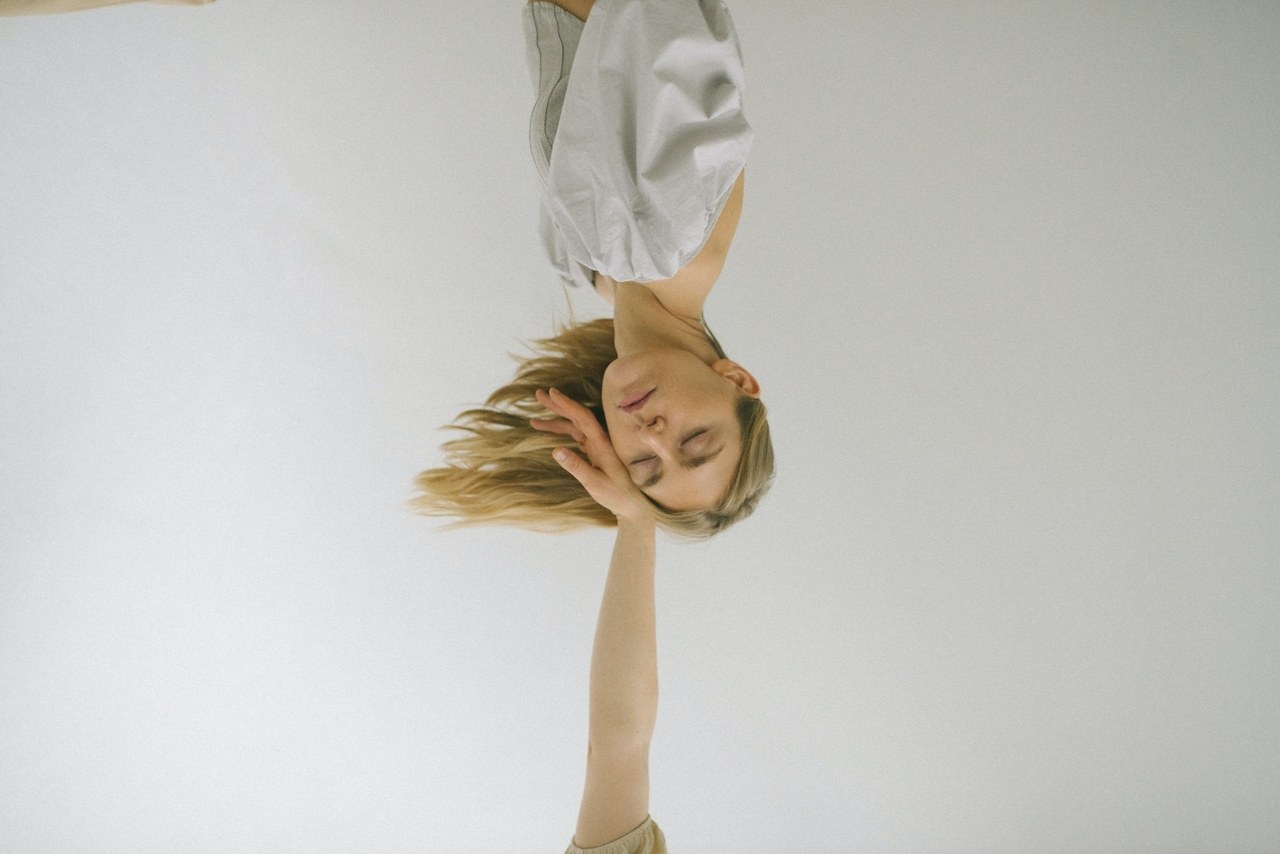 A woman who is resting on another persons hand after taking vitamins that have caused her fatigue. 