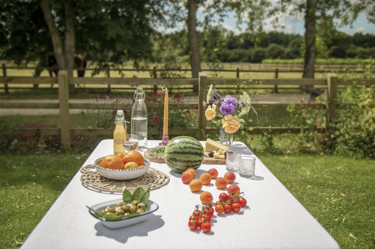 A summer picnic table with fresh fruits and flowers